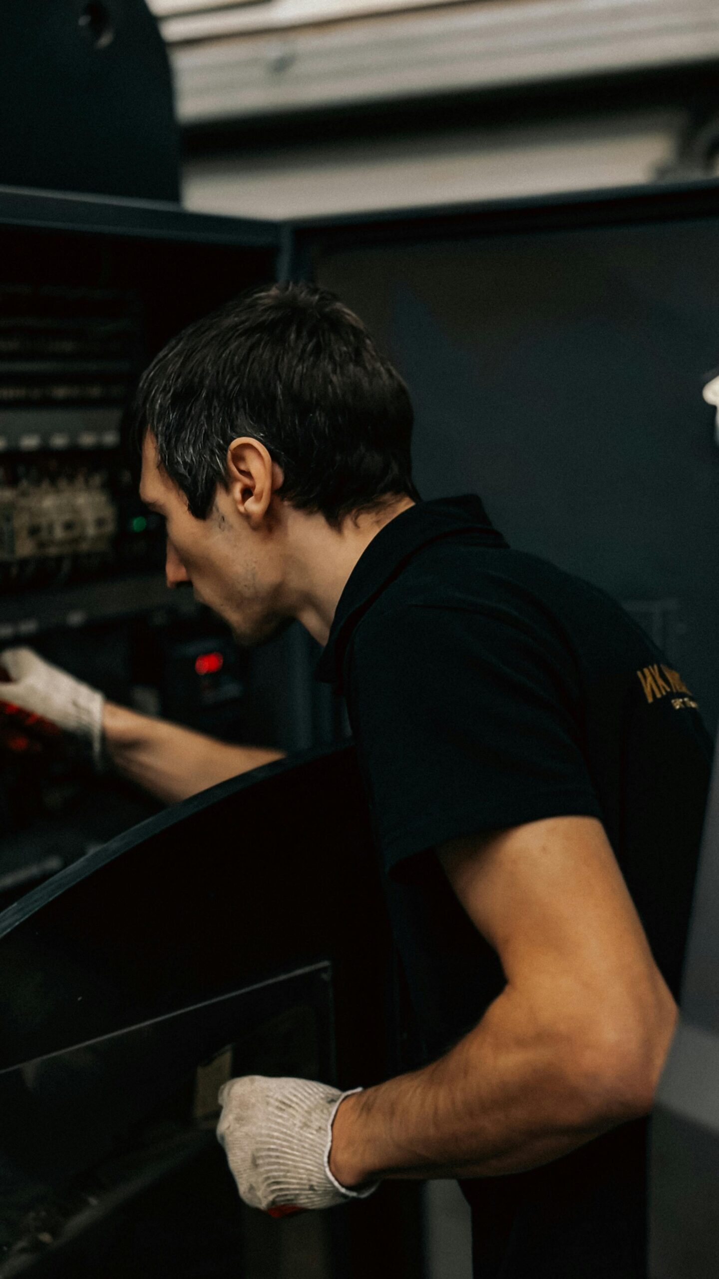 A focused technician examines industrial machinery inside a workshop.